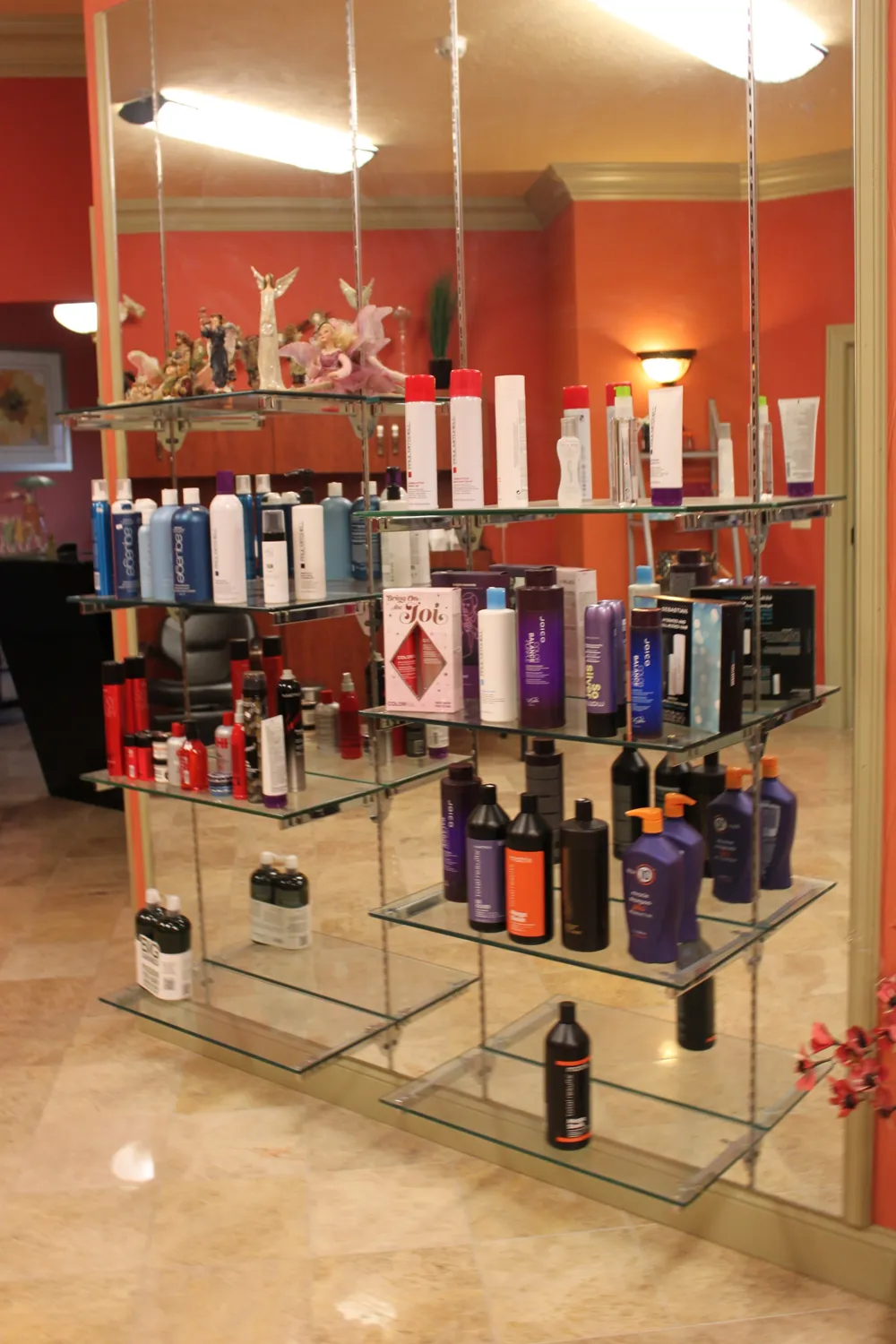Glass shelves stocked with professional hair care products at Nu Look Salon